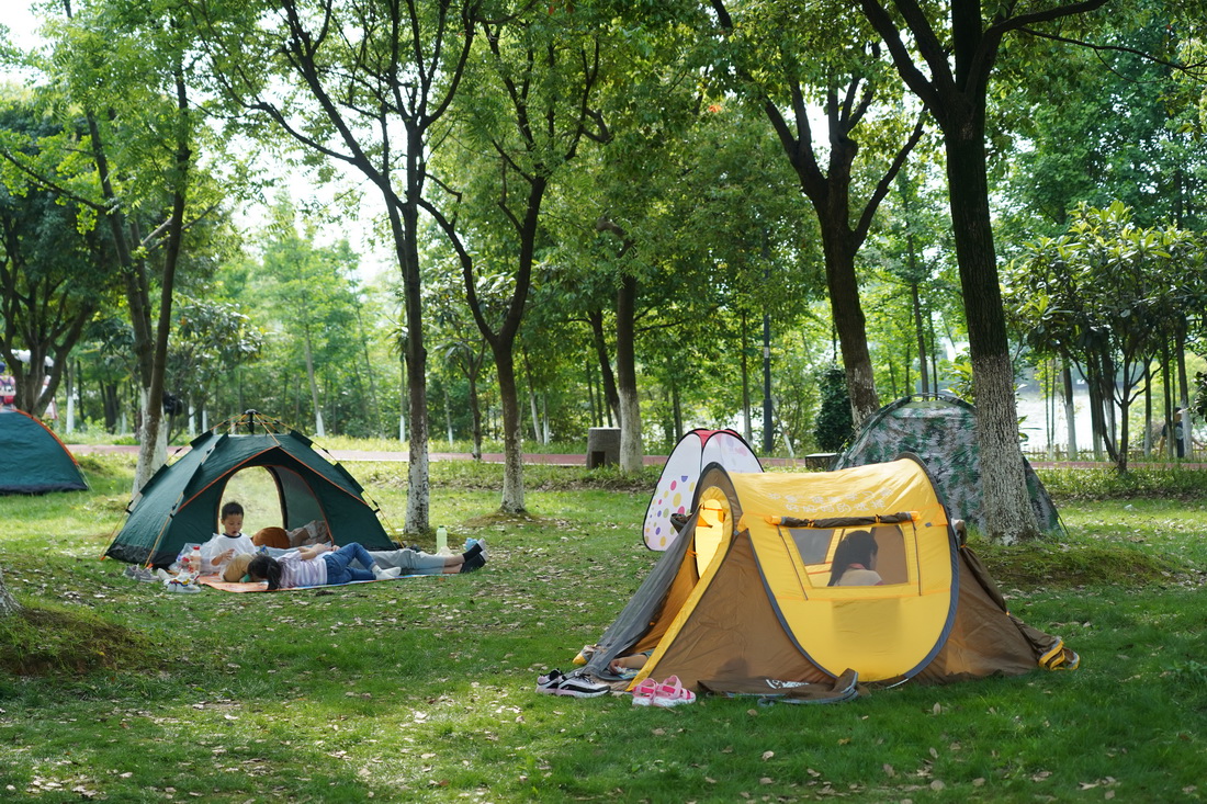 市民在南昌市艾溪湖湿地公园的草地上露营休憩（2021年5月2日摄）。新华社记者 万象 摄